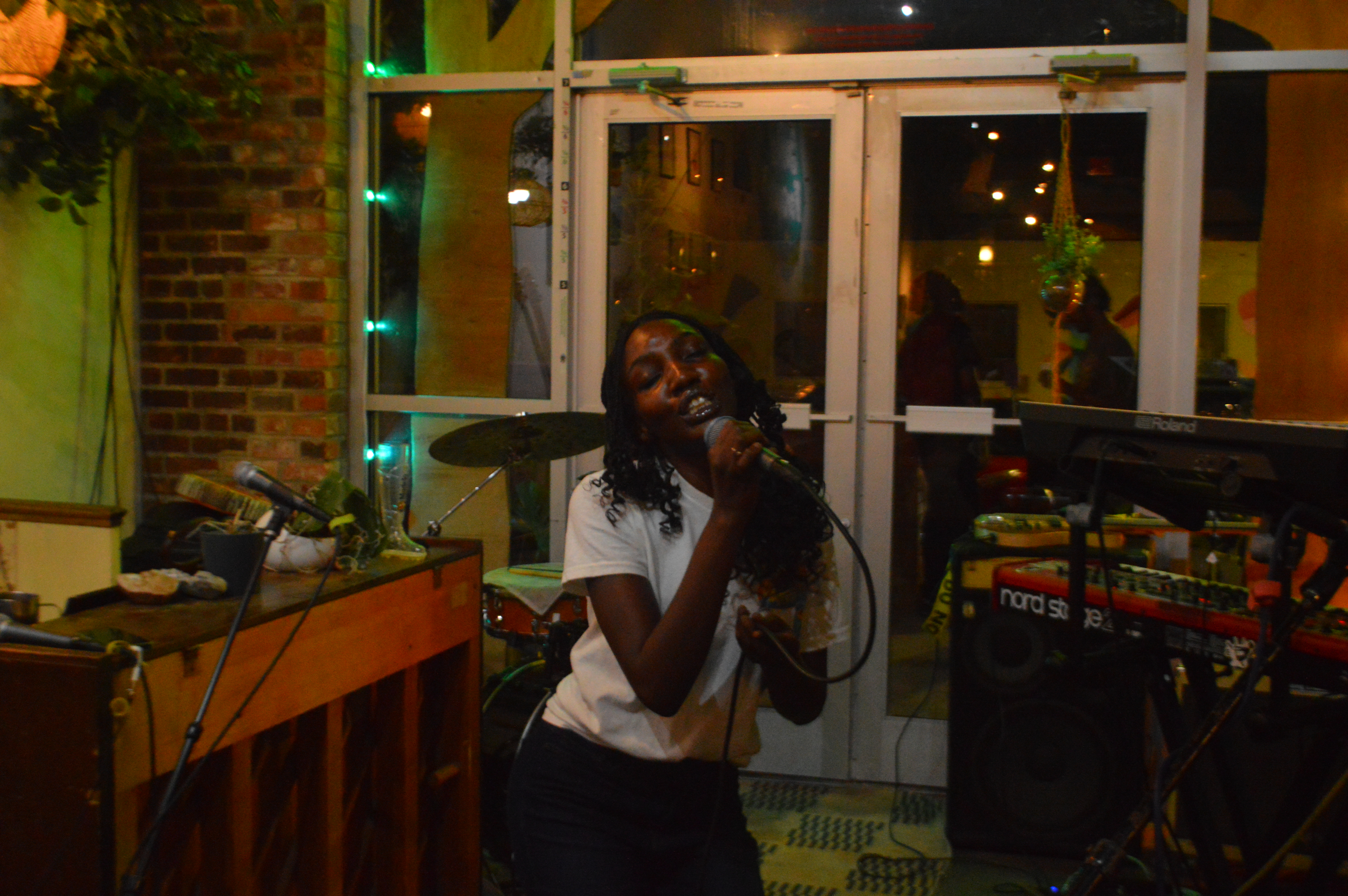 Perm Bryan performing with a microphone inside Lucky Tree.